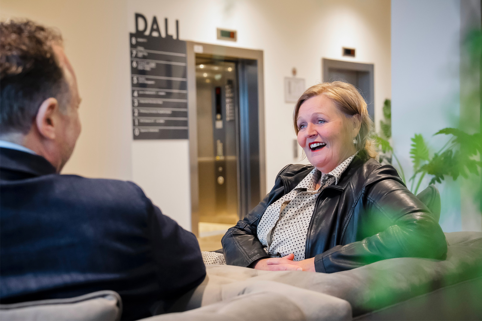 Manager die in gesprek is met medewerkers over samenwerking en ontwikkeling binnen het team.